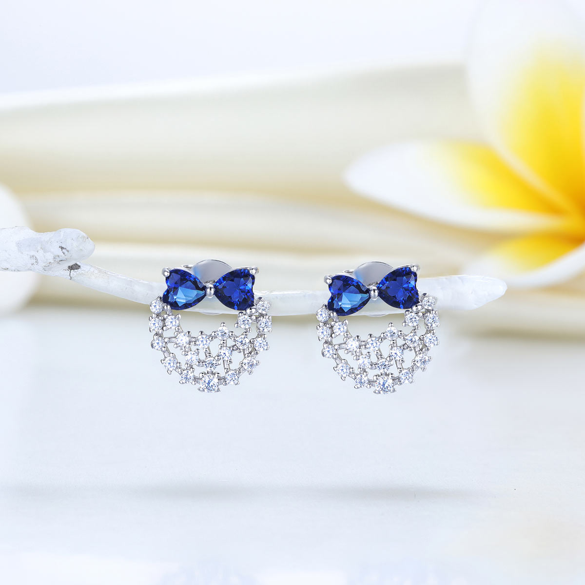 Pendientes de plata de ley con diamantes de imitación azules y lazos de corazón