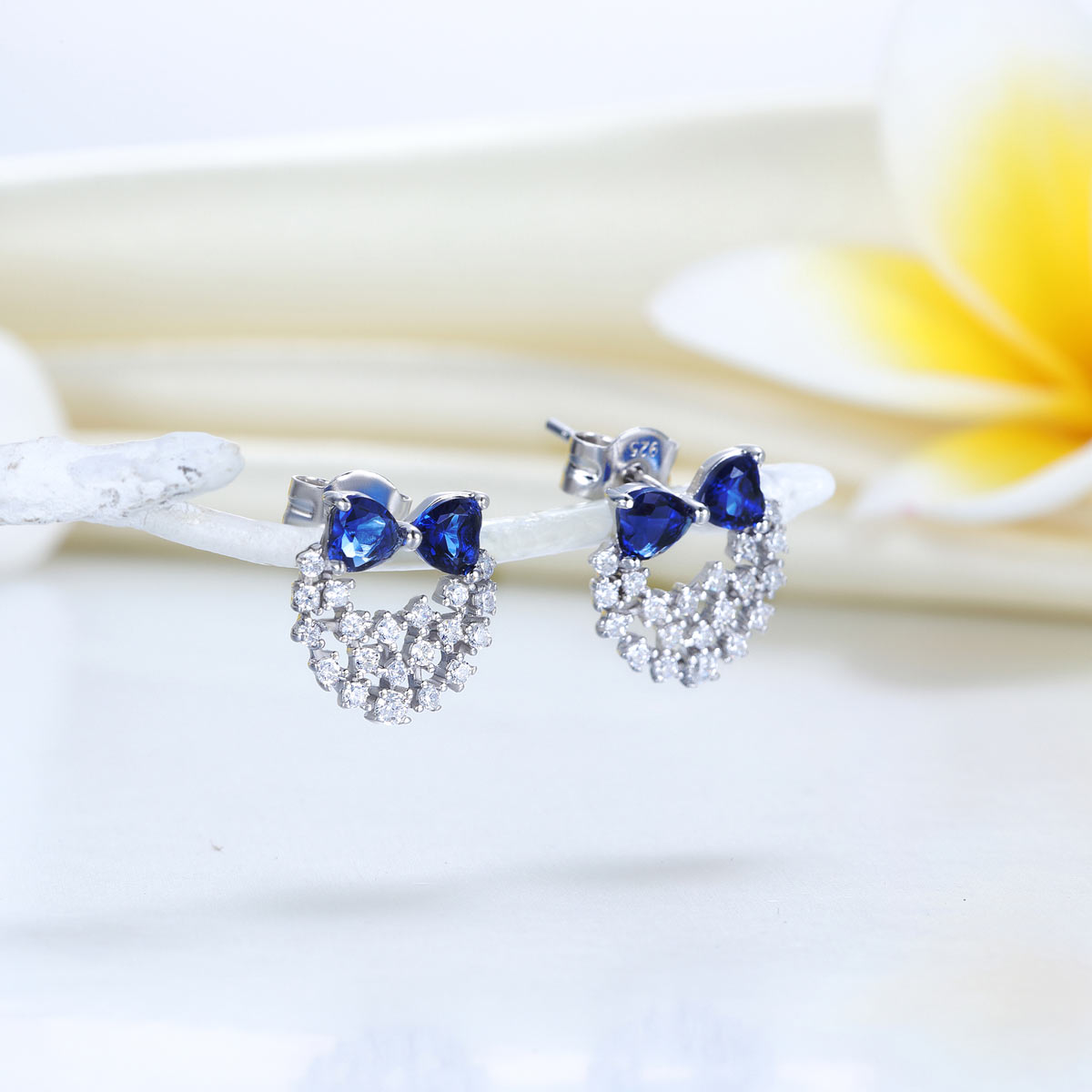 Pendientes de plata de ley con diamantes de imitación azules y lazos de corazón