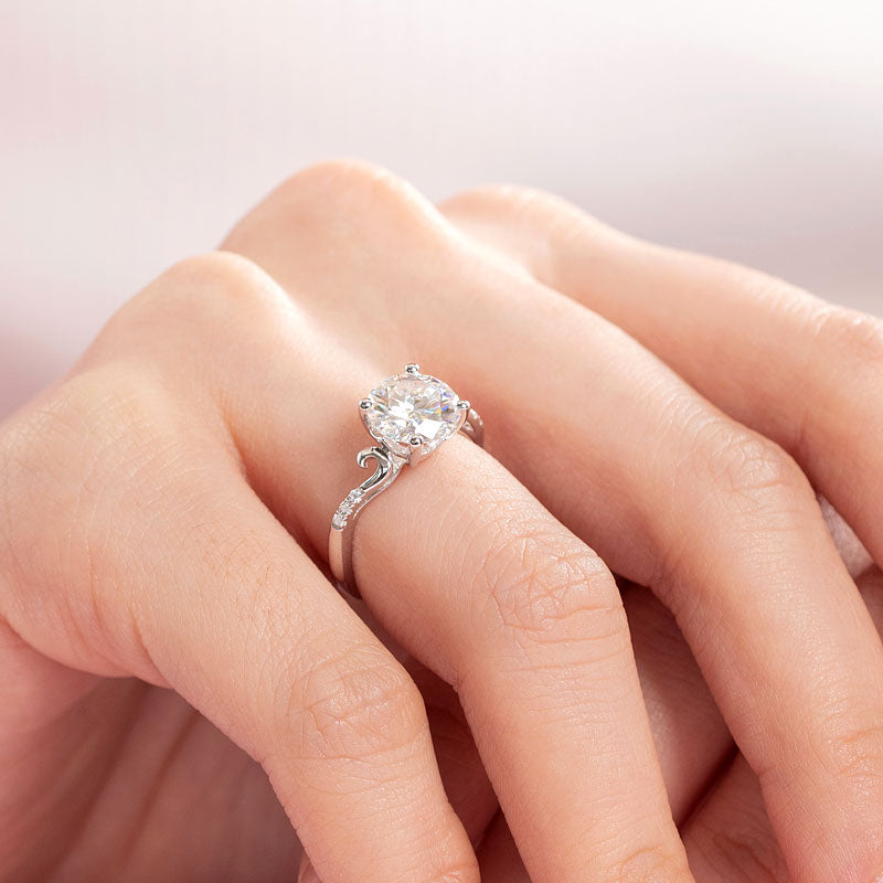 Anillo de compromiso de moissanita redonda de 2 quilates con diamante y cuerpo curvo en plata de ley.