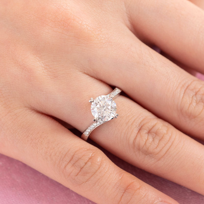 Anillo de compromiso de moissanita redonda de 1,5 quilates con forma de corazón y diamantes en plata de ley.
