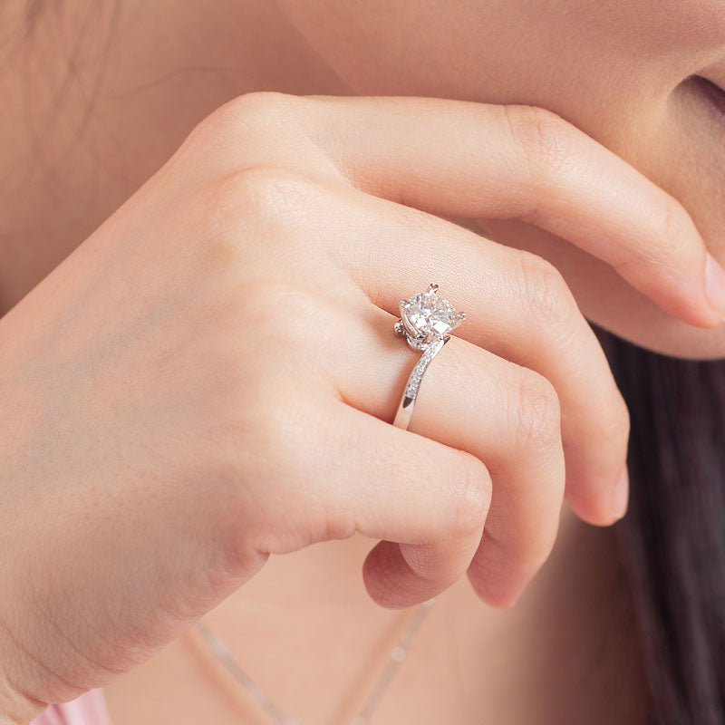 Anillo de compromiso de moissanita redonda de 1,5 quilates con forma de corazón y diamantes en plata de ley.