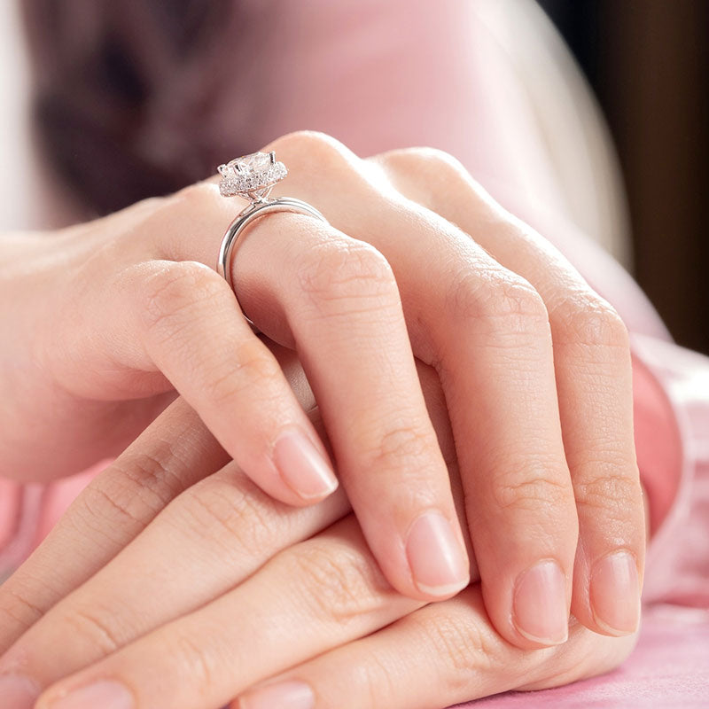 Anillo de compromiso de moissanita redonda de 1,5 quilates con halo de diamantes en plata de ley.
