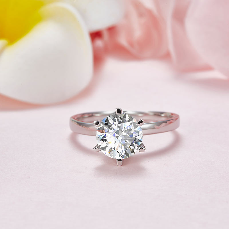 Anillo de compromiso de moissanita redonda de 2 quilates con halo de diamantes en plata de ley.
