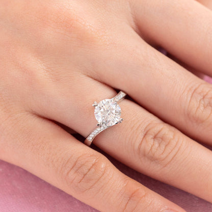 Anillo de compromiso de moissanita redonda de 1,5 quilates con forma de corazón y diamantes en plata de ley.