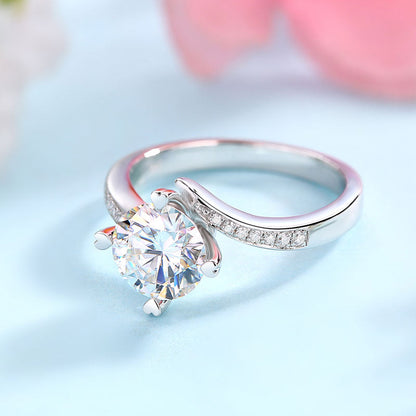 Anillo de compromiso de moissanita redonda de 1,5 quilates con forma de corazón y diamantes en plata de ley.